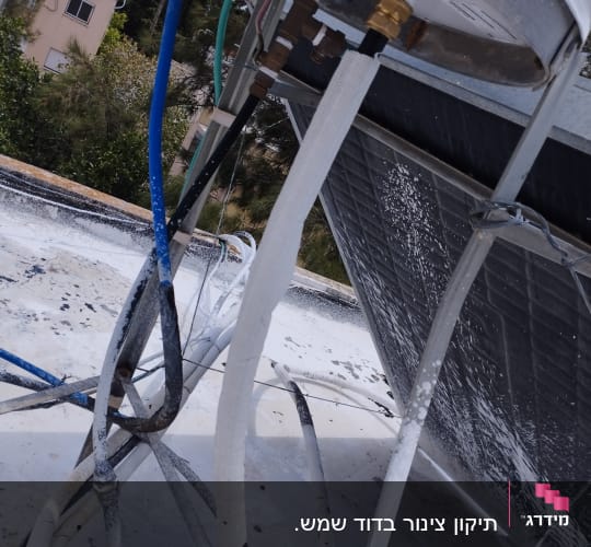 צינורות מים מחוברים לדוד שמש על גג